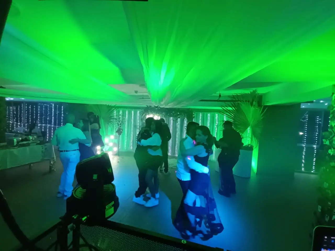 Jóvenes bailando en una fiesta de 15 años con luces verdes, humo y ambiente de celebración creado por Loop Eventos.