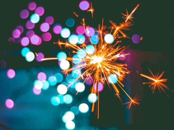 A dynamic sparkler igniting against a colorful bokeh background, perfect for celebrations.